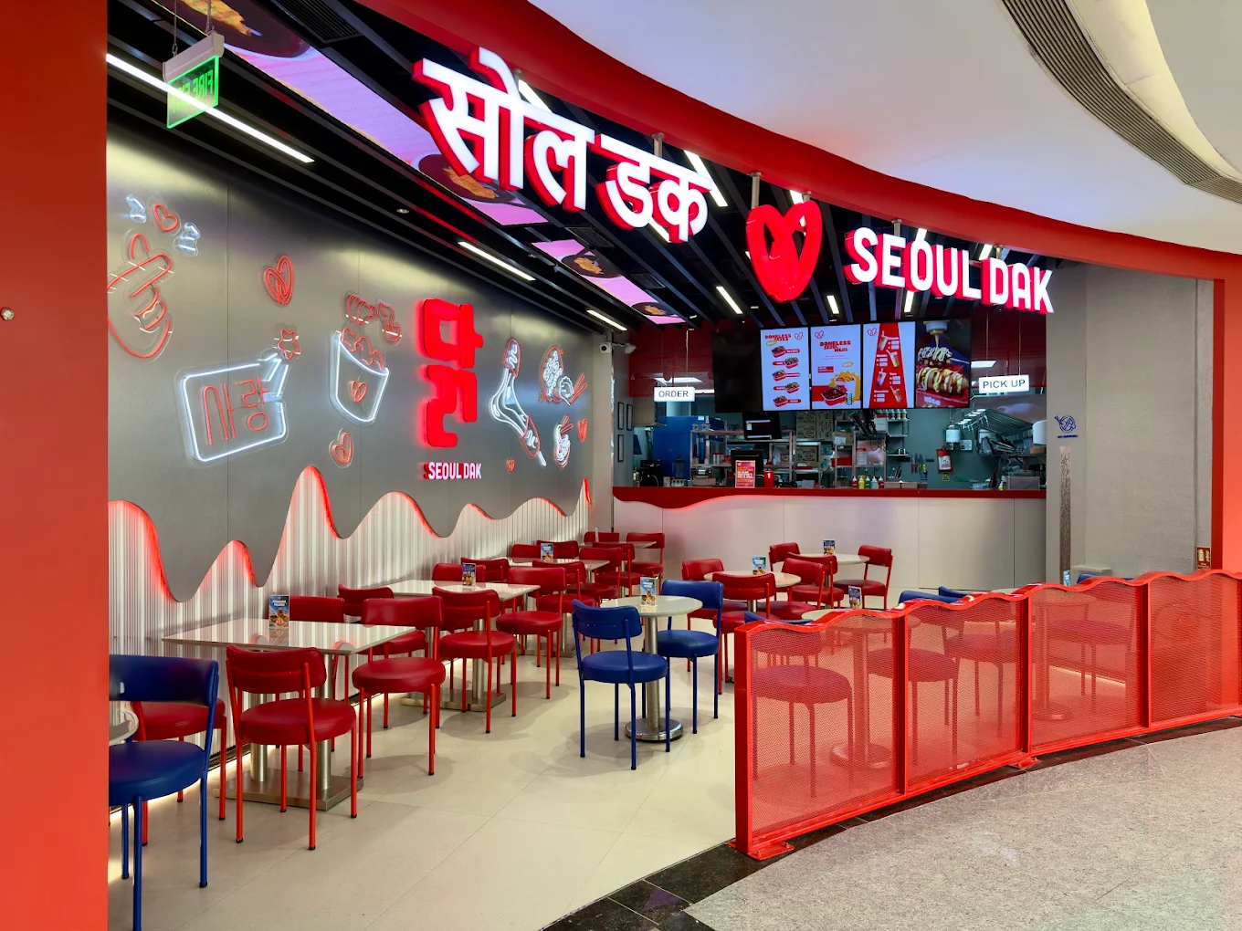 Inside a Seoul Dak outlet, a neon-lit dining space with red and blue seating